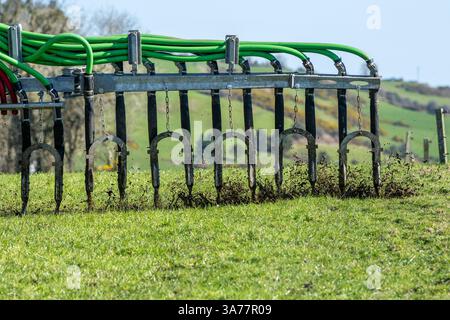 L'agriculteur épand le lisier à l'aide d'un système de pompe ombilicale et d'une barre d'égouttement. Drinagh, West Cork, Irlande. Banque D'Images