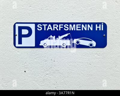 Islande, Akureyri 22. Juin 2024, bleu pas de panneau de stationnement sur le mur blanc avec dépanneuse enlevant la voiture stationnée illégalement à Akureyri, Islande Banque D'Images