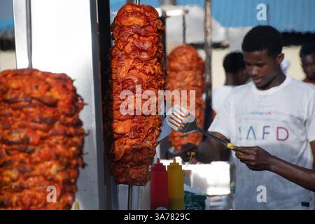 Cuisson de shawarma juteux sur une broche verticale dans un stand de nourriture local de Zanzibar. Zanzibar , Tanzanie Banque D'Images