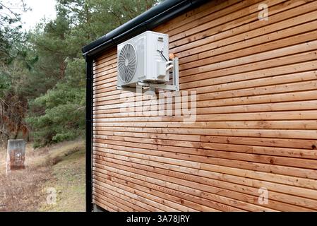 Une maison en bois de cabane en rondins avec un climatiseur sur le côté Banque D'Images