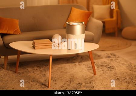 Humidificateur moderne sur table basse dans le salon le soir Banque D'Images
