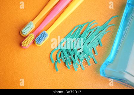 Outils d'hygiène buccale affichés sur fond orange vif Banque D'Images