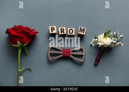 Mot PROM, noeud papillon, rose et boutonnière sur fond gris Banque D'Images