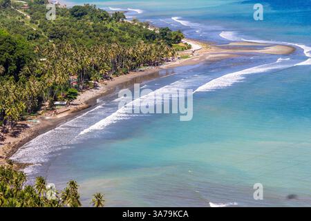 Vue panoramique lointaine de la plage avec des vagues roulantes à Malita, Davao Occidental, Philippines Banque D'Images