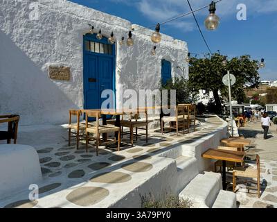 Tables et chaises sur la terrasse d'une taverne fermée dans le paisible village intérieur d'Ano Mera, sur l'île de Mykonos, en Grèce. Banque D'Images