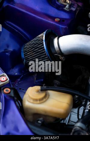 Un filtre à air haute performance dans un moteur de voiture de sport, conçu pour la vitesse et l'efficacité. Parfait pour les publicités de course et la marque de performance automobile. Banque D'Images