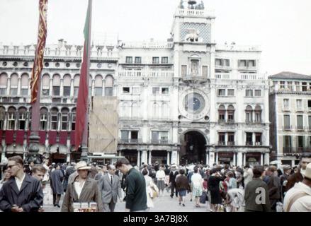 La Tour de l'horloge à Venise est un bâtiment du début de la Renaissance sur le côté nord de la Piazza San Marco, à l'entrée de la Merceria. Il comprend une tour, qui contient l'horloge, et des bâtiments inférieurs de chaque côté. Elle jouxte l'extrémité orientale de la Procuratie Vecchie. Prise en juillet 1965 sur diapositive 35 mm. Banque D'Images