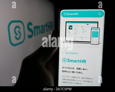 Dans cette illustration photo, une personne tient un téléphone portable avec la page Web de la société japonaise de logiciels RH SmartHR Inc sur l'écran devant le logo. (Photo timon Schneider / SOPA images/SIPA USA) *** strictement à des fins éditoriales *** Banque D'Images