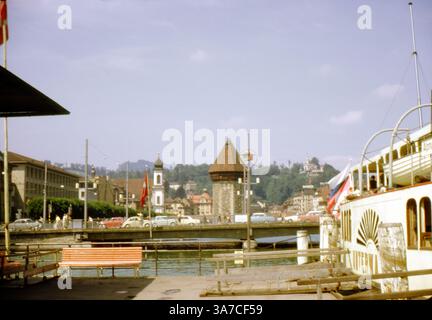 Un bateau à aubes nommé Unterwalden est amarré sur le lac de Lucerne, en Suisse, en août 1966. En arrière-plan, l’emblématique Kapellbrücke (pont de la chapelle) et le Wasserturm octogonal (château d’eau) sont des symboles du patrimoine médiéval de Lucerne. Banque D'Images