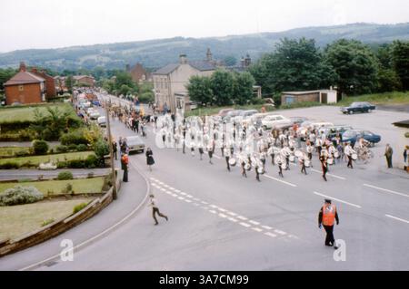 Une parade animée le jour de mai à Mirfield, dans le West Yorkshire, au cours des années 1970 Le défilé se déroule le long de Dunbottle Lane, avec des fanfares en uniforme, des bannières et des foules de spectateurs le long de la rue Banque D'Images