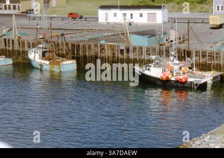 Des bateaux de pêche ont accosté au port de Yarmouth, en Nouvelle-Écosse, en juillet 1991, avec des filets disposés pour sécher sur le quai. Banque D'Images