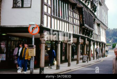 Le Butterwalk historique de Dartmouth, en Angleterre, capturé en 1991. Cette rangée emblématique de bâtiments à pans de bois, soutenue par des colonnes de granit, date du XVIIe siècle et abrite aujourd'hui des boutiques et un musée sous ses étages supérieurs distinctifs. Banque D'Images