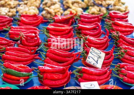 Une pile vibrante de piments rouges frais soigneusement exposés à la vente sur un marché animé de Kuching, en Malaisie Banque D'Images