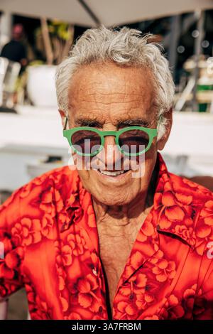 Portrait d'homme senior souriant portant des lunettes de soleil Banque D'Images