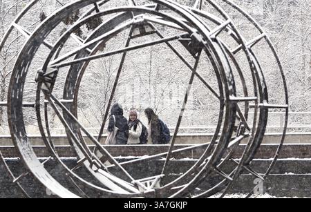 27 novembre 2012 - State College, PA, États-Unis - Un groupe de filles encadrées par une sculpture devant la Stuckeman Family Building Walk à travers la neige tombante sur le campus de l'Université Penn State, à State College, Pennsylvanie, mardi 27 novembre, 2012. (crédit image : © Nabil K. Mark/MCT/ZUMAPRESS.com) Banque D'Images