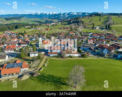 Vue aérienne du village d'Oberreute dans la source d'earla avec la chaîne de montagnes Nagelfluh enneigée en arrière-plan dans les Alpes d'Allgaeu, Bavière, Allemagne Banque D'Images