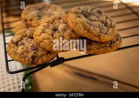 biscuits aux pépites de chocolat au levain sur une grille de refroidissement avec du sel feuilleté Banque D'Images