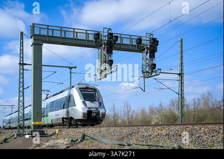 Halle, Allemagne. 27 mars 2025. Un nouveau pont de signalisation se dresse sur la ligne entre Halle et Leipzig. La nouvelle technologie de contrôle et de sécurité assure désormais des connexions plus rapides pour le trafic ferroviaire à toute la jonction ferroviaire de Halle. Après une fermeture de plusieurs jours, nécessaire à la mise en service, le trafic local, longue distance et fret reprend. Crédit : Heiko Rebsch/dpa/Alamy Live News Banque D'Images
