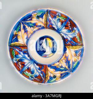 Une plaque décorative avec des motifs floraux complexes aux couleurs vives, avec un portrait de profil central qui suggère une figure élégante, entourée de feuilles et de tourbillons stylisés., Art classique avec une touche moderne réinventée par Artotop, plaque avec buste féminin, c. 1525, italien, peut-être Castel Durante, Castel Durante, faïence émaillée en étain (maiolica), diamètre : 25,9 cm (10 3/16 po.) Banque D'Images