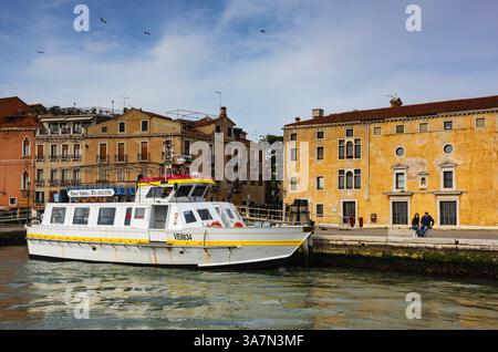 Couple assis sur le rivage dans le quartier Castello de Venise, Italie Banque D'Images