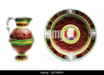 Un pichet décoratif et une assiette ornée de motifs floraux complexes et de couleurs vives, avec un portrait central entouré d'une bordure décorative., Art classique avec une touche moderne réinventé par Artotop, Shakespeare Ewer and Basin, Ewer : 1873, Basin : 1871, Minton Pottery and Porcelain Factory, Stoke-on-Trent, England, fondée en 1793, England, faïence émaillée en étain avec supports en étain Banque D'Images