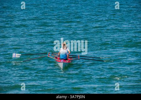 Aviron à un seul Scull sur les eaux de Fethiye : un seul rang un seul Scull Boat sur les eaux modérément agitées et ensoleillées Banque D'Images