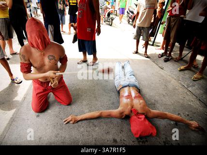 28 mars 2013 - Manille, Philippines - les pénitents cagoulés se flagellent dans un rituel pour expier leurs péchés à l'occasion du jeudi Saint de la semaine Sainte dans la ville de Mandaluyong, à l'est de Manille, Philippines, 28 mars 2013. L’Église catholique aux Philippines rejette fermement la pratique des crucifixions et des auto-flagellations comme un acte de pénitence. Les Philippines sont considérées comme l'une des plus grandes populations catholiques d'Asie avec environ 75 millions d'adeptes. (Crédit image : © Ezra Acayan/ZUMAPRESS.com) Banque D'Images