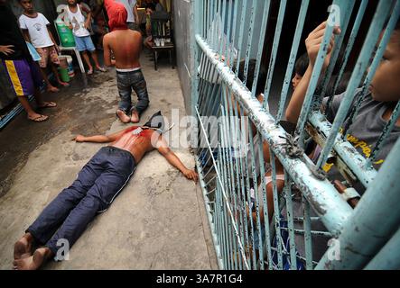 28 mars 2013 - Manille, Philippines - des enfants regardent les pénitents cagoulés se flageller dans un rituel pour expier leurs péchés à l'occasion du jeudi Saint de la semaine Sainte dans la ville de Mandaluyong, à l'est de Manille, Philippines. L’Église catholique aux Philippines rejette fermement la pratique des crucifixions et des auto-flagellations comme un acte de pénitence. Les Philippines sont considérées comme l'une des plus grandes populations catholiques d'Asie avec environ 75 millions d'adeptes. (Crédit image : © Ezra Acayan/ZUMAPRESS.com) Banque D'Images