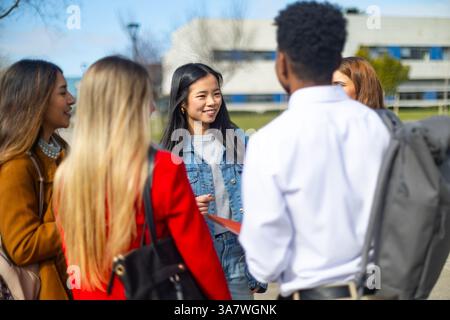 Étudiants universitaires multiethniques discutant et profitant de la compagnie de l'autre à l'extérieur sur le campus, favorisant des amitiés et des connexions Banque D'Images
