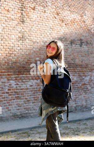 adolescent avec sac à dos et lunettes de soleil à la mode sur l'aire de jeux Banque D'Images