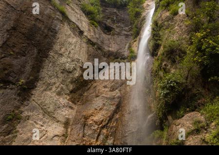 Une cascade descendant en cascade une falaise rocheuse entourée d'une végétation luxuriante Banque D'Images