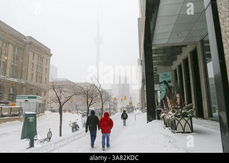 8 février 2013 - Toronto, Ontario, Canada - les piétons marchent dans une tempête de neige au centre-ville de Toronto le long de la rue Front, la Tour CN à peine visible dans la tempête. (Image de crédit : © Christopher Drost/SHIFT digital/ZUMAPRESS.com) Banque D'Images