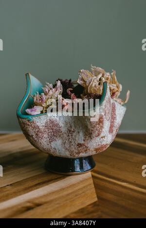 Poterie jetée à la main tenant des bourgeons de fleurs séchées Banque D'Images