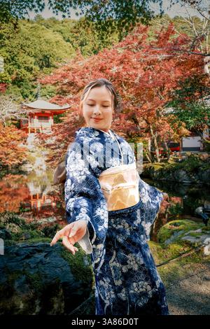 Femme japonaise posant dans l'emblématique temple Kyoto Diago-ji avec des couleurs d'automne. Pont avec sentier vers le temple japonais Banque D'Images