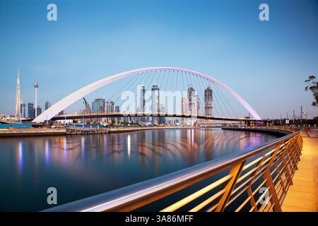 Coucher de soleil coloré sur les gratte-ciel du centre-ville de Dubaï et pont de tolérance nouvellement construit vu depuis le canal d'eau de Dubaï, Dubaï, Émirats arabes Unis Banque D'Images