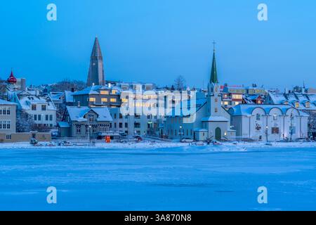 Vue de l'église Hallgrimskirkja et de la ville de Reykjavik depuis le lac Tjornin au coucher du soleil en hiver, Reykjavik, Islande Banque D'Images