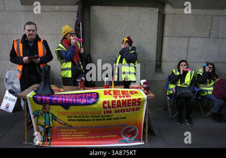 Londres, Royaume-Uni. 27 mars 2025. Les membres occupent la ligne de piquetage derrière une bannière disant « Gardez les nettoyeurs à la Chambre ». Des travailleurs, membres du Syndicat des travailleurs des nettoyeurs et des travailleurs alliés (CAIWU), organisent un piquet devant la Cour pénale du centre de Londres (Old Bailey) sur Newgate Street, à Londres. Ils font grève contre la privatisation de leurs emplois. La City of London Corporation prévoit de les transférer à de nouveaux contrats externalisés. Les travailleurs craignent pour leur avenir et ils soutiennent que cela signifiera des salaires plus bas et des charges de travail plus lourdes. (Photo de Martin Pope/SOPA images/SIPA USA) crédit : SIPA USA/Alamy Live News Banque D'Images