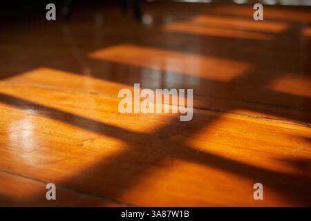 Gros plan lumière et ombre de fenêtre sur sol en bois Banque D'Images