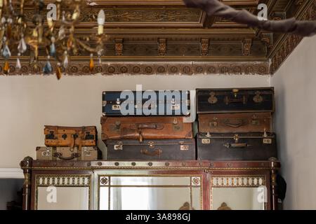 Valises vintage empilées sur le dessus d'une armoire en bois décorée dans un intérieur classique Banque D'Images