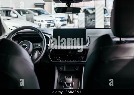 Gros plan d'un volant de voiture dans une nouvelle voiture moderne. L'intérieur d'une nouvelle voiture élégante. Concept de design élégant, de shopping et de pièces de voiture. Banque D'Images