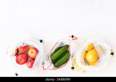 Sacs de produits réutilisables avec des fruits et légumes sur fond blanc Banque D'Images
