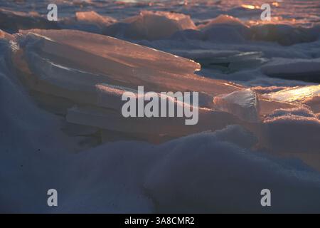 Empilés les uns sur les autres banquises sur la côte paysagère gelée de la mer Baltique, jour d'hiver au coucher du soleil. Météo et saisons, beauté de la nature Banque D'Images