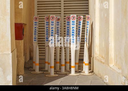Doha, Qatar - 14 janvier 2024, vue rapprochée de plusieurs panneaux en plastique, des piliers avec un panneau pas de stationnement debout dans un coin de la rue dans le Souq Waqif Banque D'Images