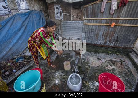 19 mars 2017 - Khulna, Khulna, Bangladesh - Bangladesh, Khulna, colonie de balayeuses Sonadanga. La plupart de ces personnes qui vivent dans ce bidonville sont des Dalits hindous, ou la caste intouchable travaillant comme balayeuses et nettoyeuses de toilettes. Il y a environ 5,5 millions de Dalits à travers le pays, ce sont les castes les plus négligées dans la société. Femmes pompant de l'eau au puits. (Crédit image : © Alison Wright via ZUMA Wire) Banque D'Images