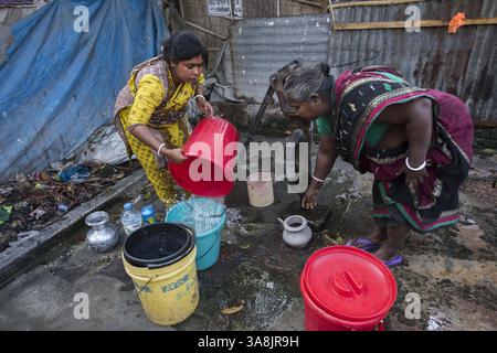 19 mars 2017 - Khulna, Khulna, Bangladesh - Bangladesh, Khulna, colonie de balayeuses Sonadanga. La plupart de ces personnes qui vivent dans ce bidonville sont des Dalits hindous, ou la caste intouchable travaillant comme balayeuses et nettoyeuses de toilettes. Il y a environ 5,5 millions de Dalits à travers le pays, ce sont les castes les plus négligées dans la société. Femmes pompant de l'eau au puits. (Crédit image : © Alison Wright via ZUMA Wire) Banque D'Images