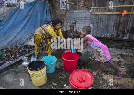 19 mars 2017 - Khulna, Khulna, Bangladesh - Bangladesh, Khulna, colonie de balayeuses Sonadanga. La plupart de ces personnes qui vivent dans ce bidonville sont des Dalits hindous, ou la caste intouchable travaillant comme balayeuses et nettoyeuses de toilettes. Il y a environ 5,5 millions de Dalits à travers le pays, ce sont les castes les plus négligées dans la société. Femmes pompant de l'eau au puits. (Crédit image : © Alison Wright via ZUMA Wire) Banque D'Images
