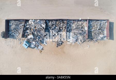 Un tas de déchets est empilé en une rangée. Les ordures sont principalement composées de métal et de bois. Concept de gaspillage et de négligence Banque D'Images