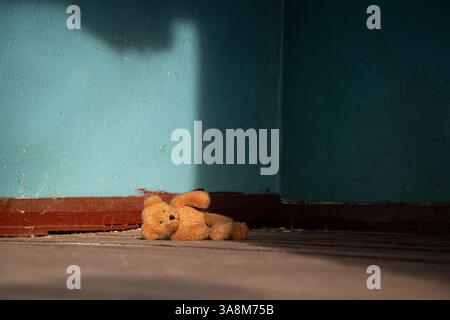 Un ours en peluche doux brun est abandonné sur le sol dans une vieille maison abandonnée en Ukraine, un jouet abandonné Banque D'Images