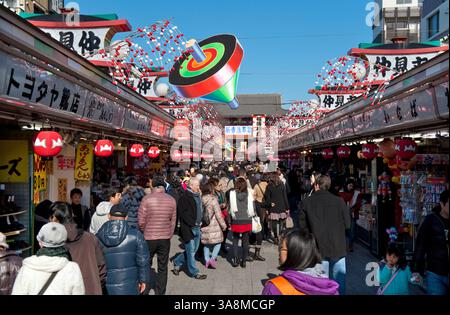 Les visiteurs et les touristes du temple fréquentent l'étroite rue commerçante Nakamise-dori menant au temple bouddhiste de Sensoji à Asakusa, Tokyo, Japon. Banque D'Images
