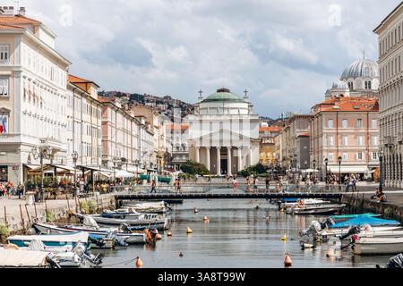 Trieste, Italie - 18 août 2024 : vue sur le canal Grande à Trieste, avec des bateaux et des bâtiments colorés bordant le front de mer Banque D'Images
